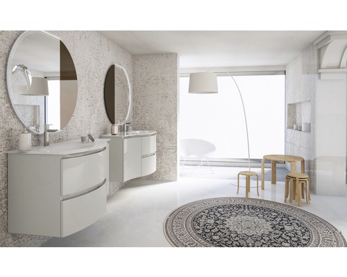 Ljust badrum med handfat, speglar, matta och dekorationer.