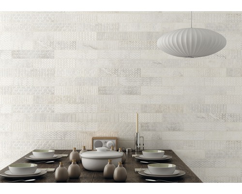 Väggdekoration med ljusa, mönstrade plattor ovanför ett matbord.