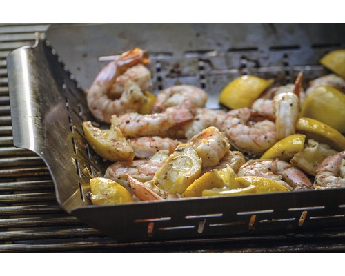 Grillskål med räkor och citroner på en grill