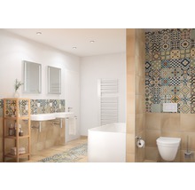 Ljust badrum med handfat, speglar, badkar, toalett och kakel med mönster