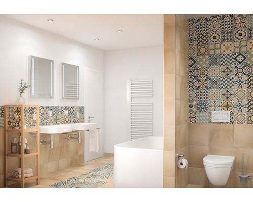 Ljust badrum med handfat, speglar, badkar, toalett och kakel med mönster