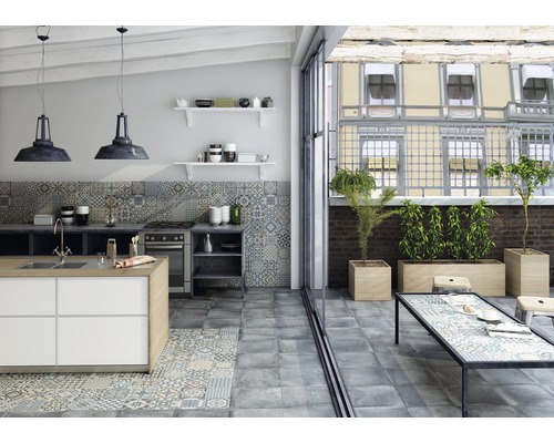 Ljust kök med köksö, klinkergolv, köksbord och växter på terrassen