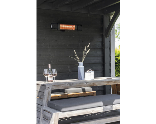 Terrassscen med terrassvärmare, träbord, bänkar, dekoration och drycker