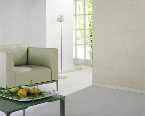 Ljust vardagsrum med fåtölj, bordslampa och fönster