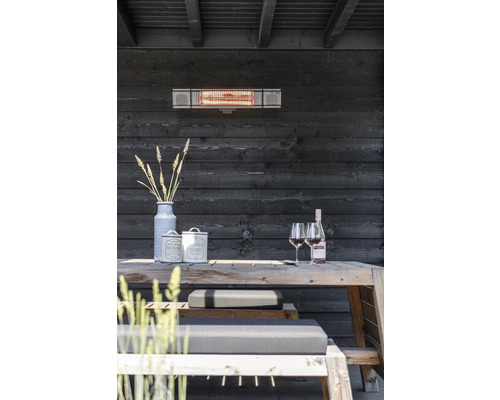 Terrass med värmelampa, träbord, bänkar och dekoration