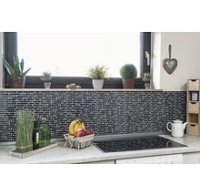 Köksscen med mosaikplattor, fönsterbräda med växter, fruktkorg och spishäll.