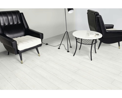 Interiör med två fåtöljer, bord och golvlampa på ljust trälaminat