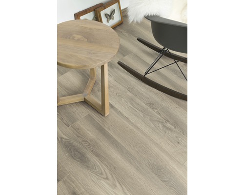 Ljust rum med trägolv, runt bord och gungstol