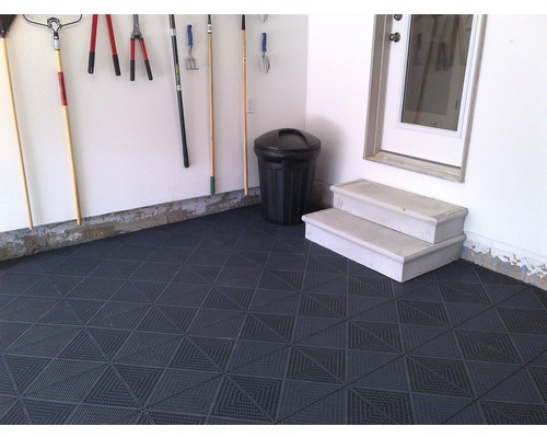 Garage med golvplattor, trädgårdsredskap och soptunna