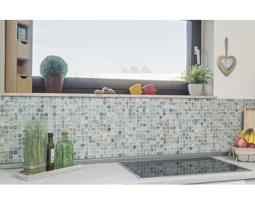 Kökets stänkskydd med mosaikplattor och dekorationer på bänkskivan