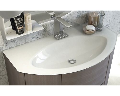 Detaljvy av ett tvättställ med armatur, hylla och skötselprodukter