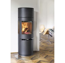Kamin med glasgolvplatta i ett vardagsrum med trägolv och stolar.