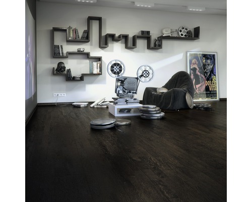 Vardagsrum med mörkt trägolv, projektor, bokhylla och filmaffisch