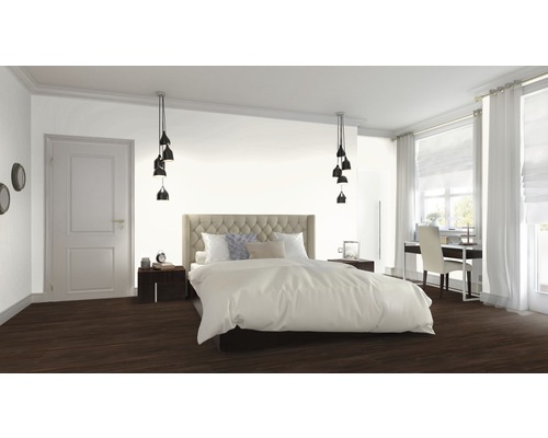 Sovrum med säng, sängbord, lampor och arbetsplats vid fönstret.