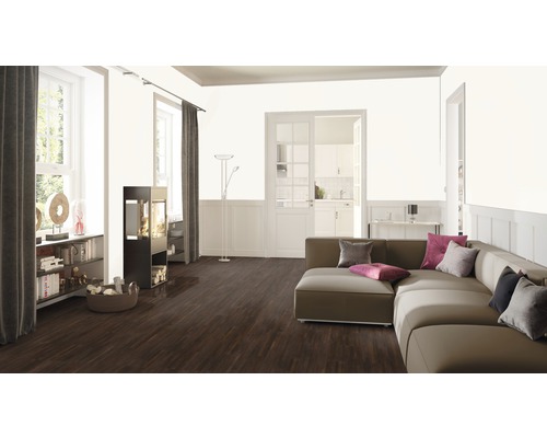 Vardagsrum med soffa, eldstad, bokhylla och trägolv.