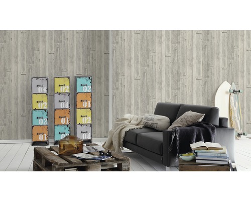 Vardagsrum med grå tapet i trälook, svart soffa och färgglada metallskåp som dekoration.