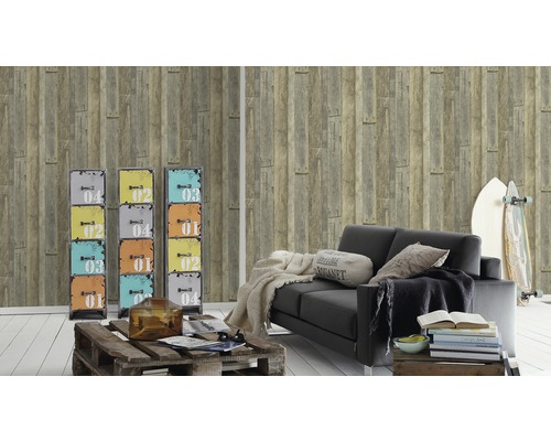 Vardagsrum med träpanelstapeter, svart soffa, surfbräda och färgglada skåp