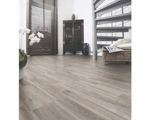 Ljust rum med laminatgolv, spiraltrappa och byrå