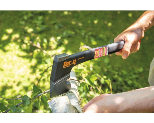 En person använder en yxa av märket for_q för att hugga ved.