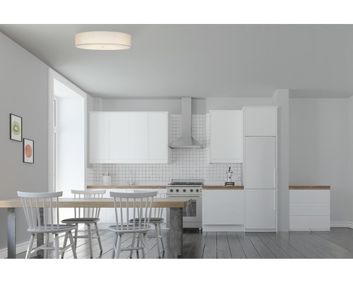 Ljus matsal med matbord, stolar, taklampa och pentry