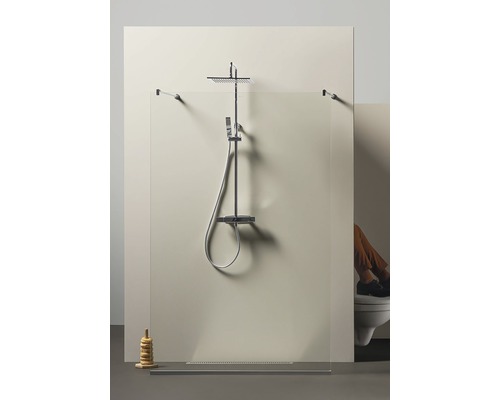 Duschkabin med regndusch och duschhuvud framför en duschvägg