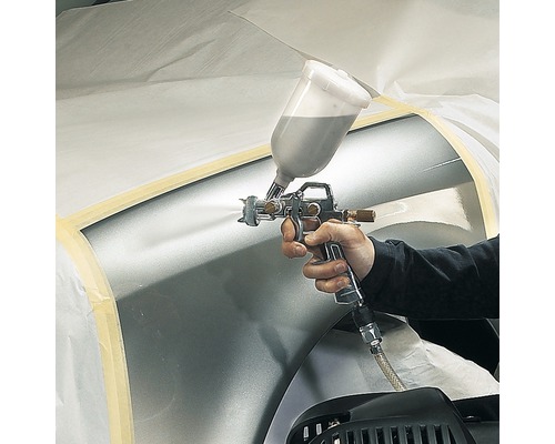 Målare använder färgsprutpistol för att måla ett fordon