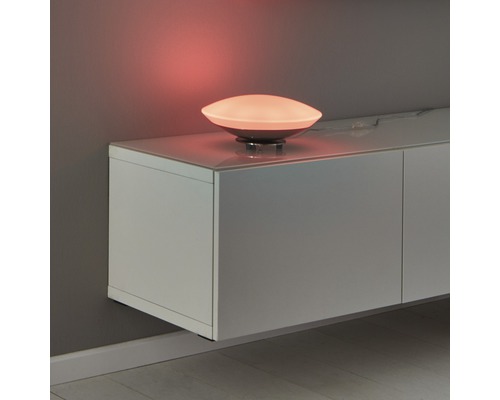 Dekorativ bordslampa på ett lågt skåp med belysning.