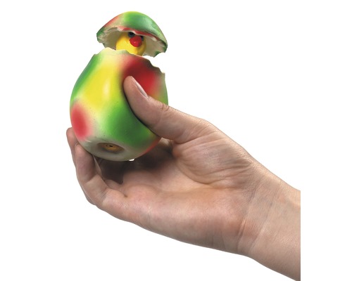 En hand håller en leksakskyckling i ett ägg