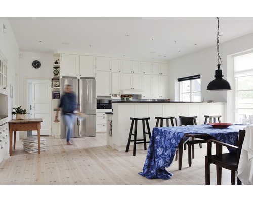 Ljust kök med matplats, vita skåp och köksö