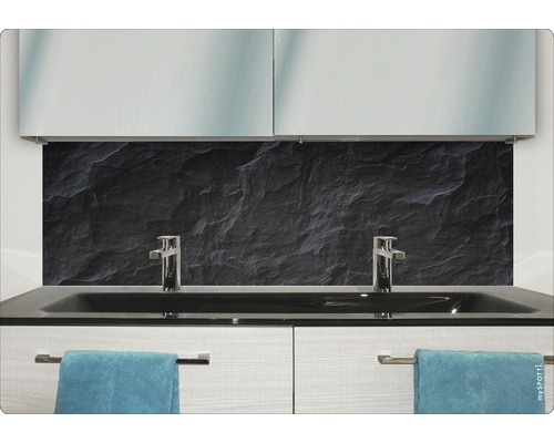 Modernt badrum med svart stenbakgrund, handfat och handdukar