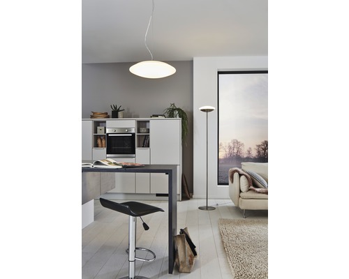 Ljust vardagsrum med pentry, taklampa och golvlampa.