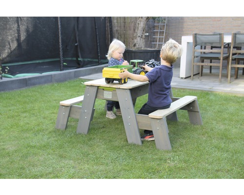 Barnsittgrupp i trädgården med två barn som leker