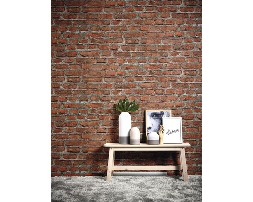 Dekorativ scen med en röd tegelvägg, en bänk och hemtillbehör