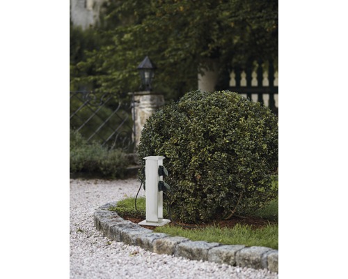 Elfördelningsstolpe utomhus bredvid en buske