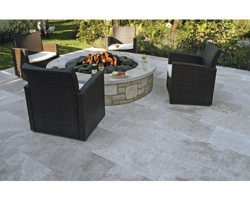 Trädgårdsscen med eldstad, stenplattor och rottingfåtöljer