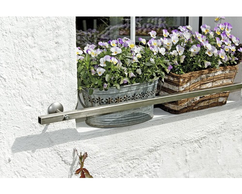 Blomlådor med violer på fönsterbrädan med räcke