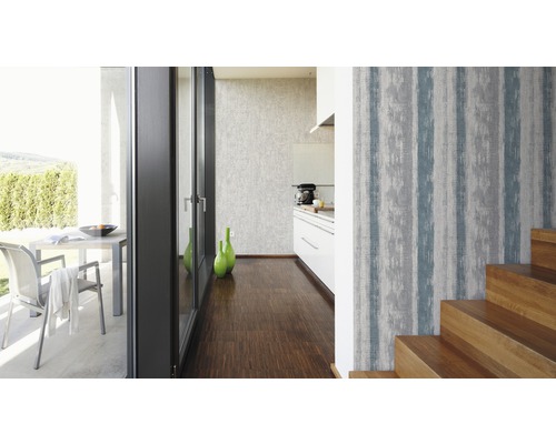 Vardagsrum med mönstrad tapet, trappa och altandörr