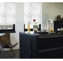 Ljust kök med fönsterrullgardiner med blommönster, köksö och stol