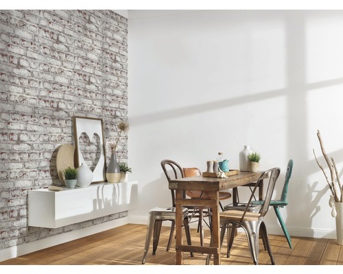 Vardagsrum med tapet i tegel, hylla och matbord med stolar.