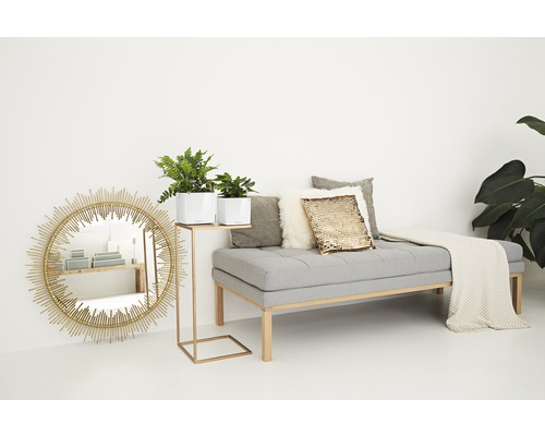 Vardagsrum med spegel, bänk, kuddar och växter