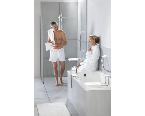 Ljust badrum med badkar, duschkabin och handtag för ökad säkerhet