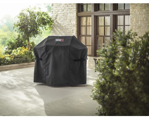 Täckt grill med Weber-logotyp på en terrass