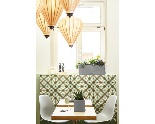 Scen av ett ljust rum med bord, stolar, växter och hängande lampor