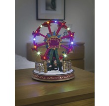 Belyst, rörligt pariserhjul som juldekoration med figurer.