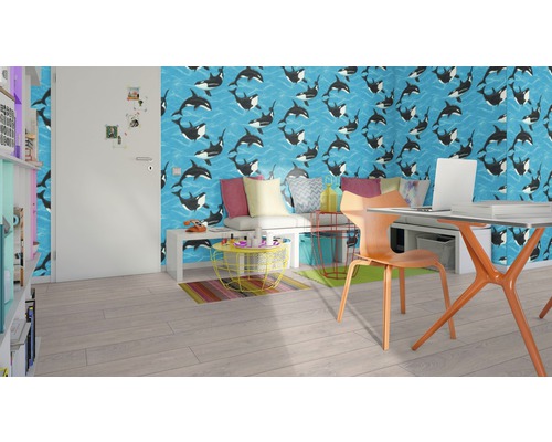 Modernt rum med tapet som visar ett valmönster, ett skrivbord med bärbar dator, en stol och en hylla.