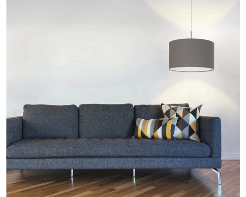 Vardagsrum med grå soffa, geometriska kuddar och hänglampa