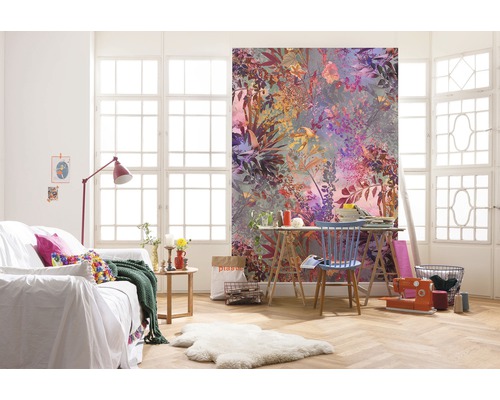 Vardagsrum med blommig fototapet, soffa och arbetsbord framför ett fönster