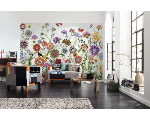 Vardagsrum med blommig fototapet, fåtöljer och träbord