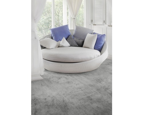 Rund rottingfåtölj med kuddar i ljust rum