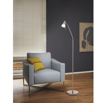 Vardagsrum med fåtölj, golvlampa och persienner